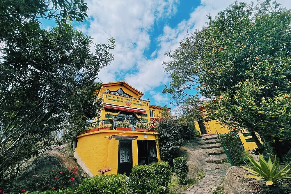 Casa Realidasd y Ensueno — The center is set amidst a dramatic landscape of mountains and ancient boulders, offering expansive, breathtaking views from every vantage point. The atmosphere is one of deep connection to nature and the spiritual heritage of the land, with native plants and flowers adorning the ceremonial courtyard.