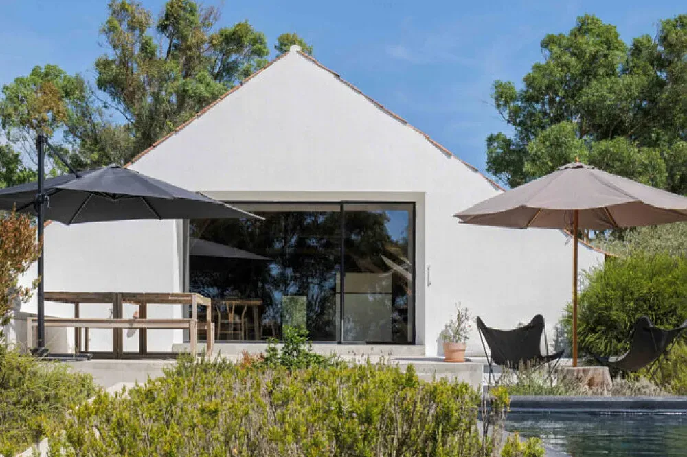 Casas na Ferraria — The retreat is nestled within a natural estate in Portugal, characterized by century-old cork oaks, fragrant pine trees, and open meadows. This creates a tranquil and immersive environment, allowing guests to connect deeply with the natural rhythm of the land.