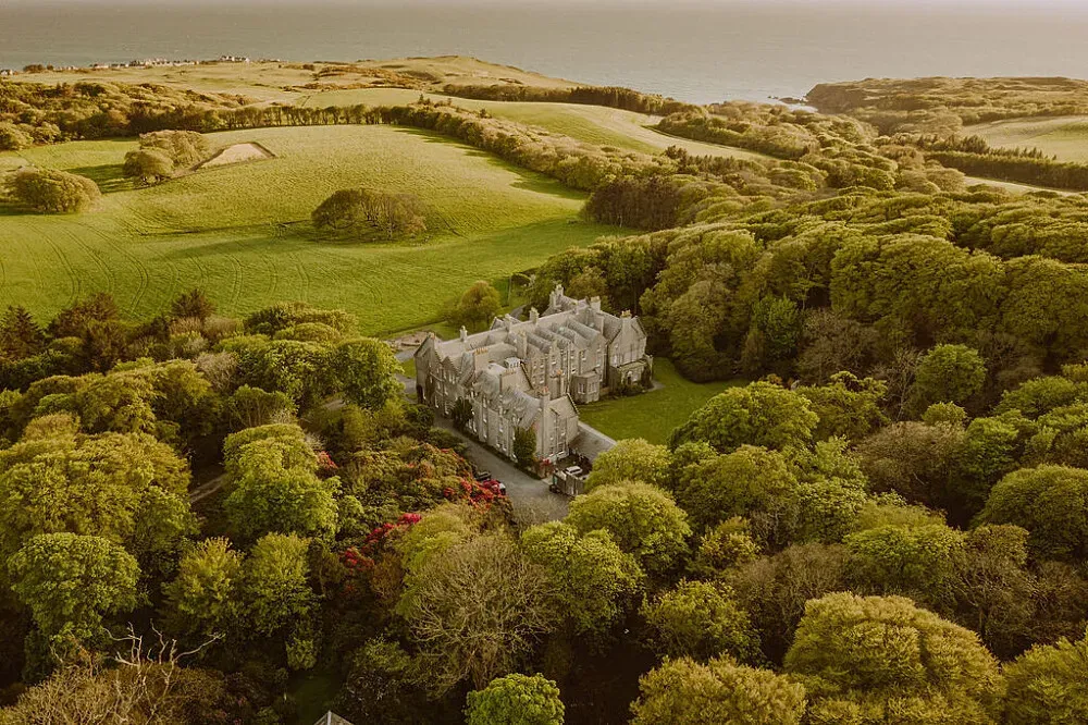 Dunskey Estate — Dunskey Estate is set amidst 2000 acres of breathtaking Scottish countryside, boasting panoramic views that encompass both the rolling land and the expansive sea. The atmosphere is one of serene grandeur, with an Edwardian castle and luxurious lodges providing a refined backdrop to the wild beauty of the landscape.