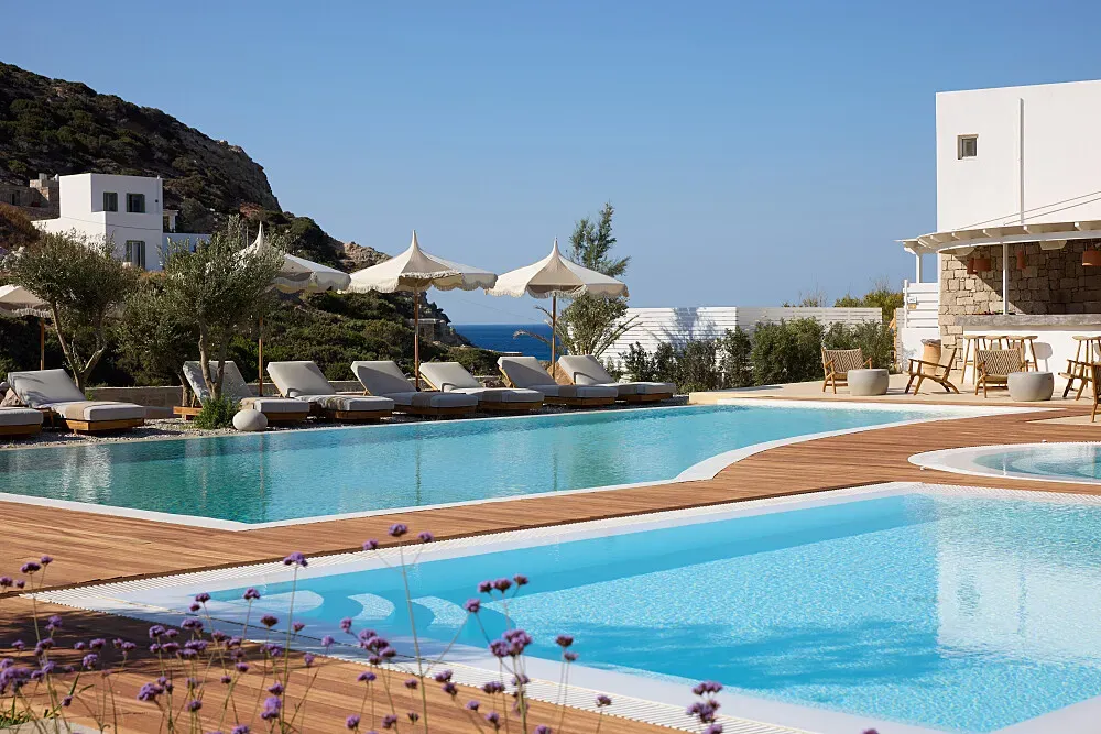 Golden Milos Beach House — Perched directly on the coastline of Milos, this retreat boasts a prime beachfront location. The island itself is renowned for its stunning volcanic landscapes, pristine beaches, and charming villages, providing a naturally serene and picturesque environment. The atmosphere here is one of sophisticated tranquility, with the calming presence of the Aegean Sea always nearby.