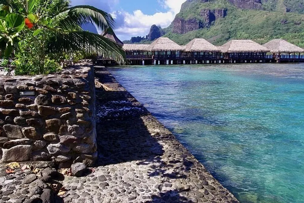Hotel Kaveka — Hotel Kaveka is situated directly on Cook's Bay in Moorea-Maiao, offering an idyllic tropical setting. The landscape is dominated by the dramatic peaks of Mount Rotui, which provides a stunning backdrop to the calm waters of the bay. The atmosphere is one of serene natural beauty, with the sounds of the ocean and the lush Polynesian environment creating a peaceful escape.