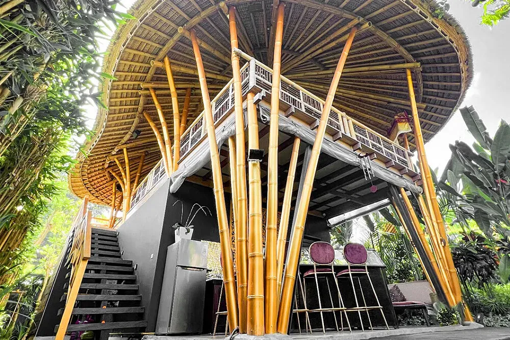 Joyously Raw — The center is situated amidst the vibrant, world-renowned landscape of Ubud, Bali. Its multi-level bamboo structures are integrated with the natural surroundings, offering views of the jungle canopy and a sense of being deeply connected to the tropical environment.