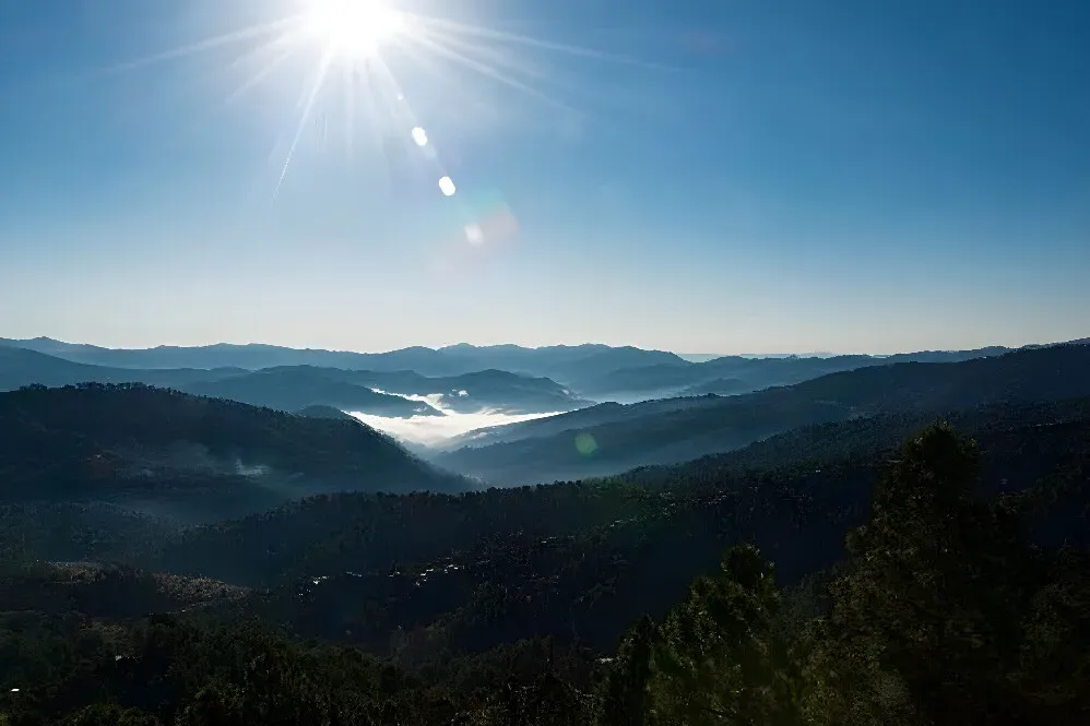 Kasar Devi Rainbow Yoga Retreat — The retreat is situated on the scenic Binsar-Almora road in Uttarakhand, a region revered as "The Land of the Gods." This location promises breathtaking views and a peaceful atmosphere, ideal for introspection and spiritual practice amidst the majestic Himalayan landscape.