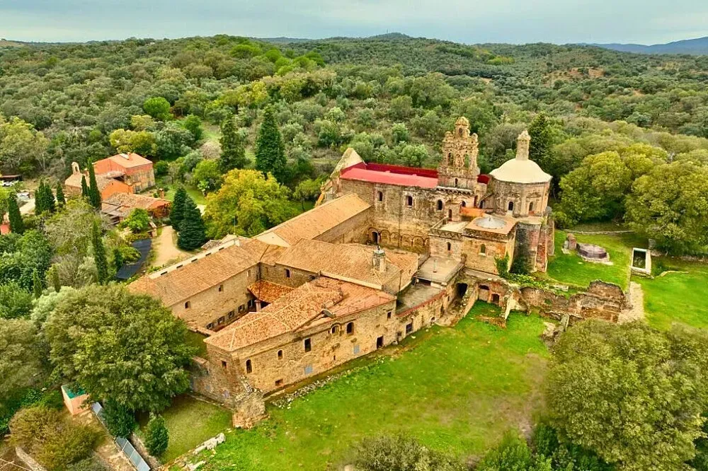 La Cartuja de Cazalla — The monastery is located in the Sierra Morena Mountains, north of Seville, an area renowned for its natural beauty. It's part of a UNESCO Starlight Reserve, ensuring exceptionally clear night skies. The landscape features impressive red rock formations, waterfalls, and diverse wild plants, creating a deeply peaceful and historically rich atmosphere.