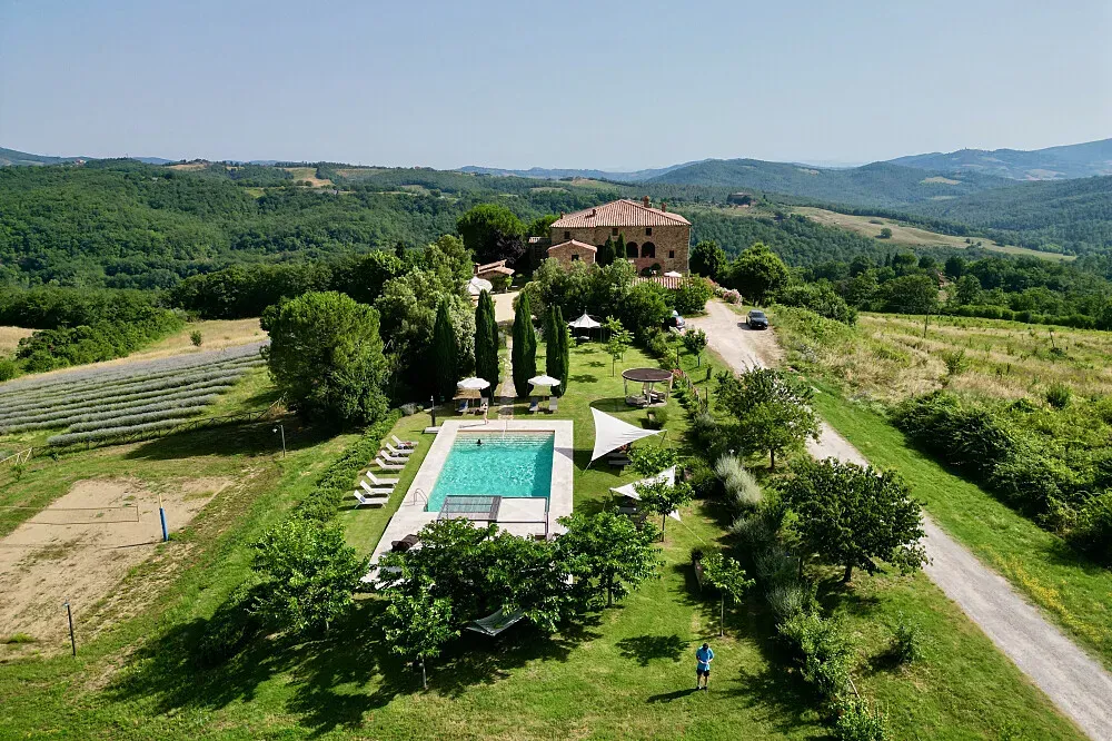 Locanda Cugnanello — The estate is set within the rolling Tuscan hills, surrounded by an untouched and wild landscape. Nature is a dominant presence, with lavender fields, lush gardens, and expansive views creating an atmosphere of profound peace and natural beauty.