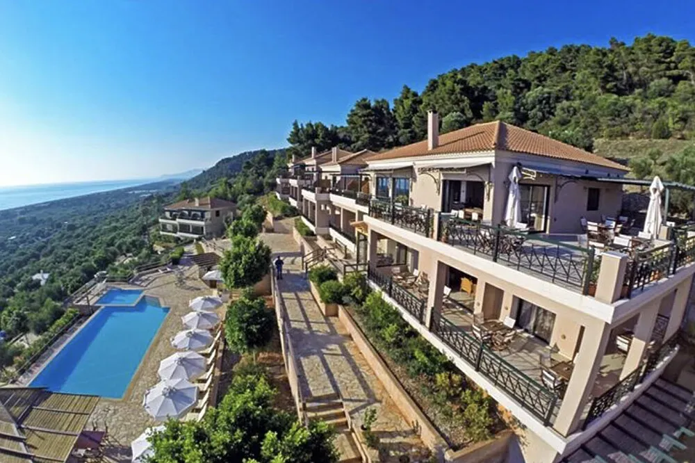 Natura Club & Spa — Perched on a hillside within a 10-acre olive grove, Natura Club & Spa overlooks the expansive Bay of Kyparissia, known for the Mediterranean's longest beach. The landscape is a harmonious blend of mountains, lush forests, and ancient olive trees, an area recognized for its outstanding natural beauty and protected by the World Heritage Society. The gentle sea breeze and the rustling of leaves create a naturally calming atmosphere.