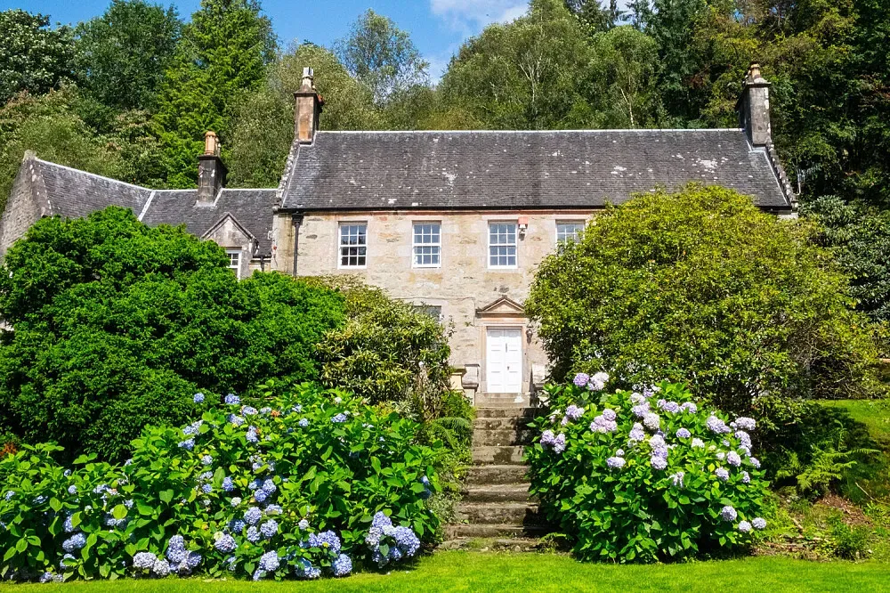 Old Kilmun House — The house is located near Dunoon, in an area known for its natural beauty. While specific details about the immediate surroundings aren't provided, the mention of James Duncan, founder of Benmore Botanic Garden, hints at a connection to lush landscapes and botanical wonders. The atmosphere within the house itself is described as oozing with charm and character, suggesting a peaceful and aesthetically pleasing environment.