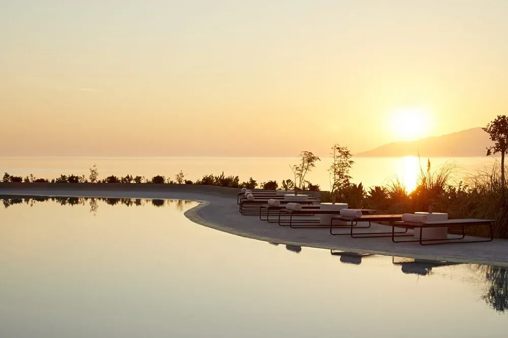 Parocks Hotel — The hotel is situated on the island of Paros in the Cyclades, offering breathtaking panoramic views of the Aegean Sea. The atmosphere is one of serene luxury, with the natural beauty of the Greek islands providing a tranquil backdrop.