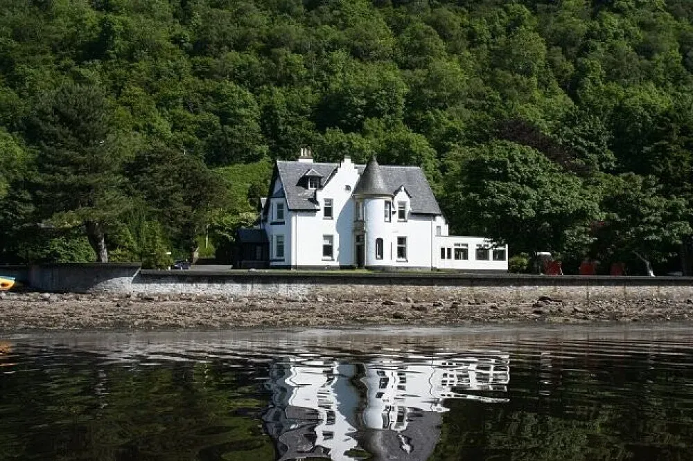 Retreat Centre Scotland — The center is set within the dramatic landscapes of the Scottish Highlands, specifically on the shores of Loch Long. The surrounding Arrochar Alps provide a breathtaking backdrop, creating an atmosphere of profound natural beauty and peaceful seclusion. Guests can enjoy the private beach and barbecue area, soaking in the panoramic views.