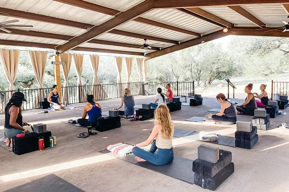 Retreat Ranch — The retreat is situated on a sprawling 46-acre ranch, providing a scenic and expansive natural environment. The atmosphere is distinctly nature-forward and animal-loving, offering a peaceful escape with plenty of space to explore and unwind amidst the Texas landscape.