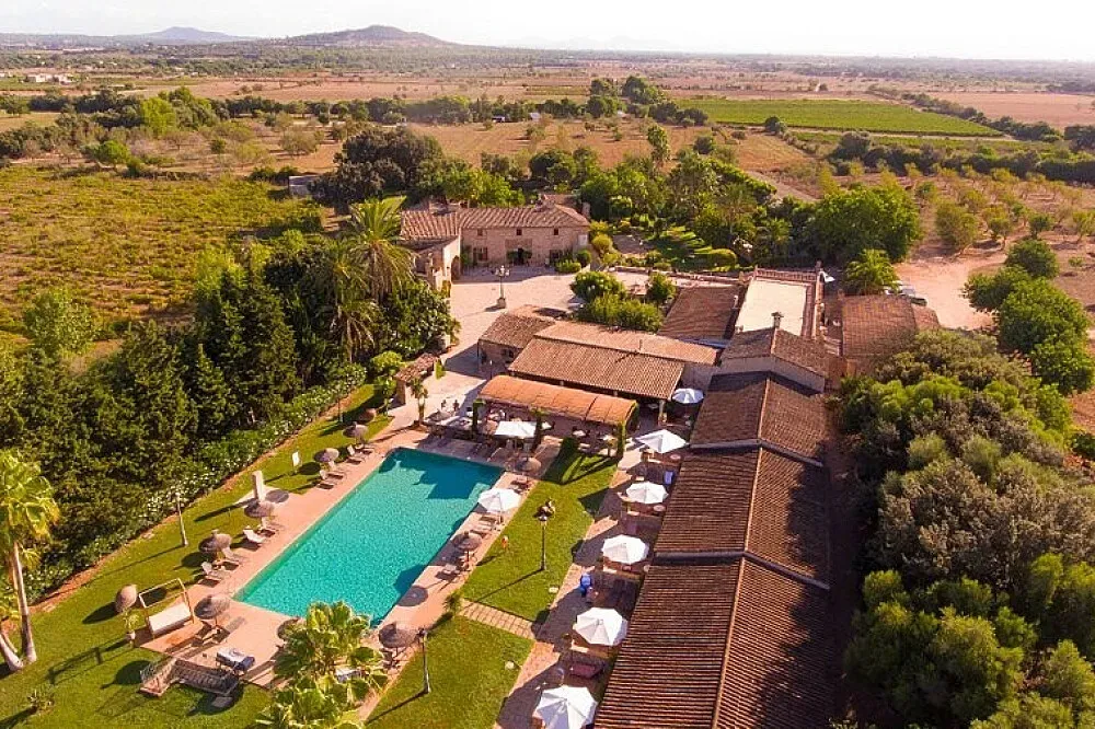 Sa Bassa Rotja Ecoturisme — The center is set within a magnificent 100-hectare historic estate in Mallorca, enveloped by a million square meters of pristine natural landscape. The atmosphere is one of profound seclusion and Mediterranean ease, with the grounds boasting extensive groves of almond, olive, palm, and citrus trees, creating a verdant and tranquil environment.