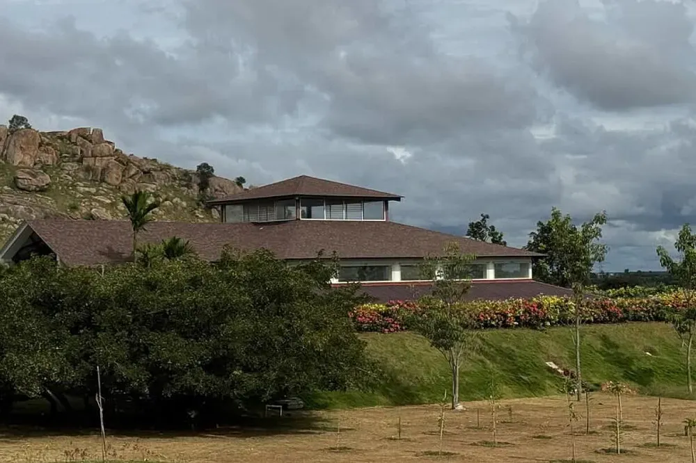 Shathayu Ayurveda Yoga Retreat — The retreat is set amidst a verdant landscape, characterized by gentle hills and the calming presence of a tranquil lake. This natural setting ensures a constant supply of fresh air and provides a serene atmosphere, making it an ideal environment for relaxation and rejuvenation. The visual appeal of the surroundings contributes significantly to the overall sense of peace.