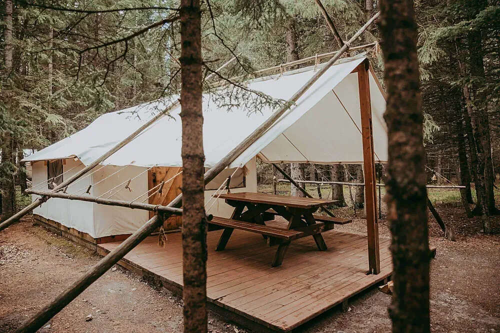 Sundance by Basecamp — Overlooking the Kananaskis River, Sundance by Basecamp is set in the heart of Kananaskis Country, surrounded by the dramatic peaks of Canada's Rocky Mountains. The atmosphere is one of serene wilderness, offering a true escape into nature with ample opportunities for outdoor exploration and quiet contemplation.