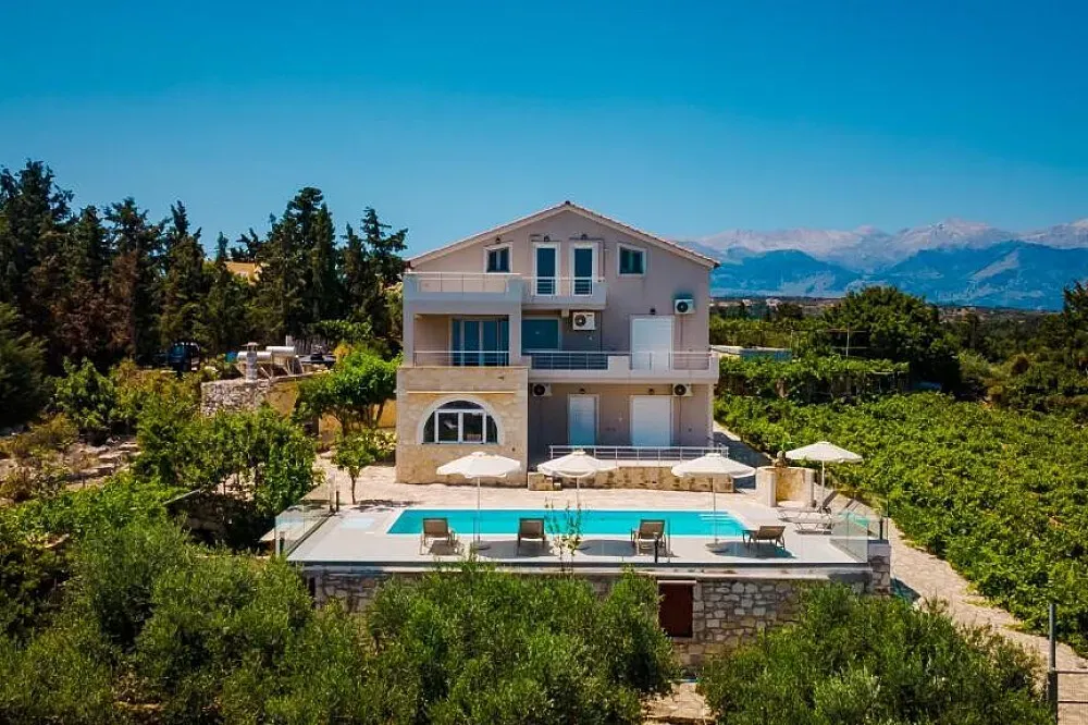 Villa Konstantinos Hilltop Vineyard Escape — Nestled on a hillside overlooking the valley and the sea, Villa Konstantinos is surrounded by lush olive groves and verdant vineyards. The atmosphere is one of peaceful seclusion, yet the vibrant village of Almyrida and the city of Chania are easily accessible, offering a balance of nature and local culture.