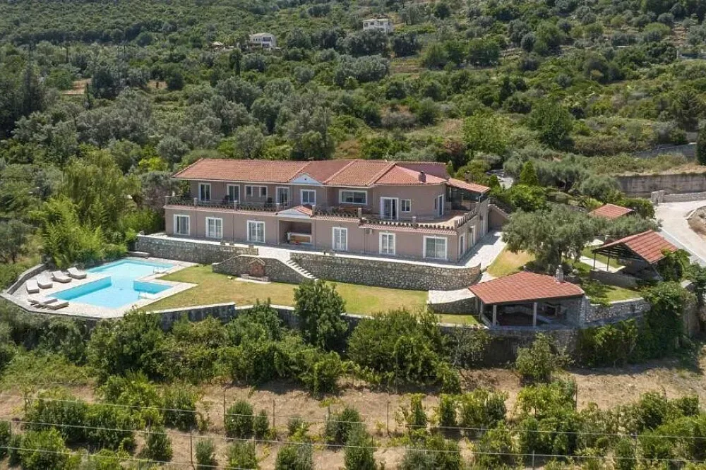 Villa Rafael Retreat — The retreat is situated on a hilltop in Nikiana, a charming area of Lefkada. This elevated position provides expansive, uninterrupted vistas of the Ionian Sea, creating a sense of calm and spaciousness. The surrounding landscape is typical of the Greek islands, with lush greenery meeting the azure waters.