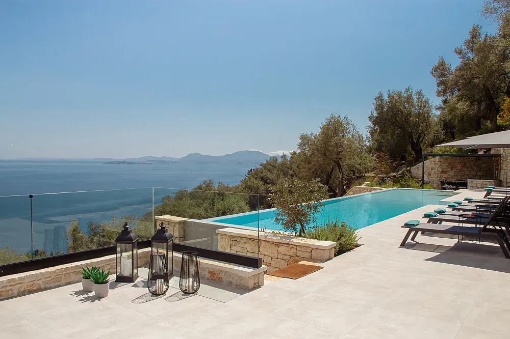 Villa Saphira — Perched in Nisaki, Corfu, Villa Saphira boasts a breathtaking location with panoramic views of the Ionian Sea. The atmosphere is one of serene luxury, offering a peaceful escape amidst the natural beauty of the Greek island.