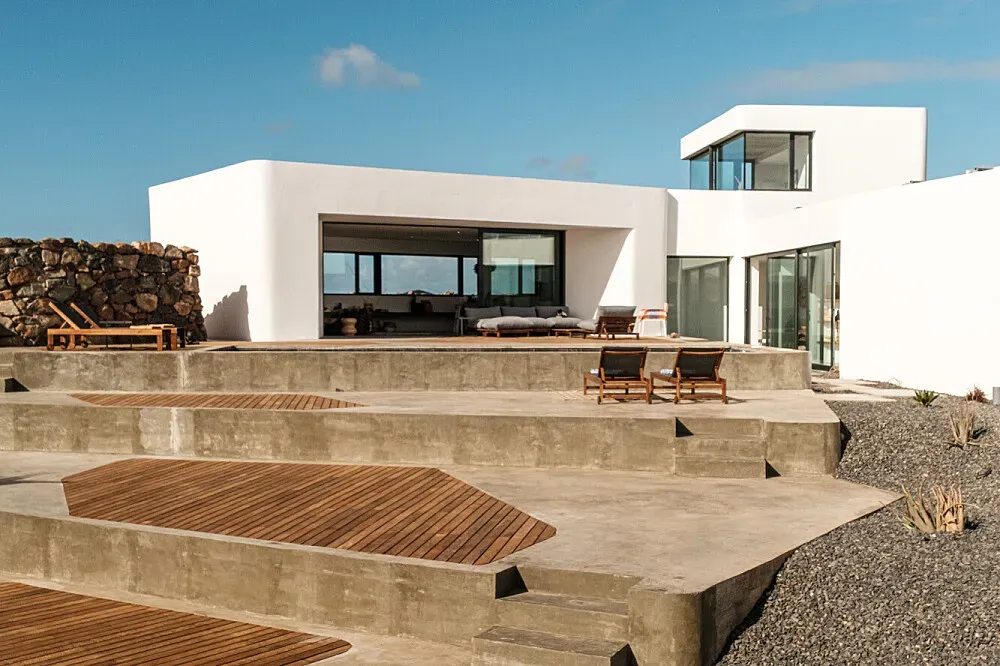 Villa Simone — Villa Simone is situated in Fuerteventura's desert, offering expansive horizons and a profound sense of stillness. The surrounding landscape is vast and quiet, creating an atmosphere of deep tranquility, while the villa itself is a luminous white structure designed with local art and creativity in mind.