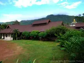 Dhamma Ābhā — The center is situated on a verdant plateau, framed by towering mountains to the east. The expansive 61-hectare grounds are meticulously designed with numerous ponds, fruit trees, and bamboo, creating a deeply calming and natural atmosphere.