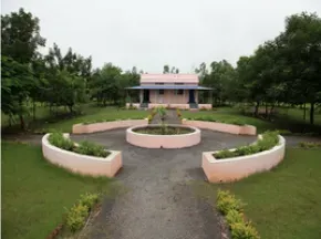 Dhamma Anakula — Dhamma Anakula is situated about 5 km from Telhara town, surrounded by vast stretches of fertile agricultural fields. This rural location provides a naturally quiet and undisturbed atmosphere, ideal for focused meditation. The 6-acre property itself is simple, yet thoughtfully maintained with plenty of trees and well-kept gardens, contributing to a sense of peace and natural beauty.