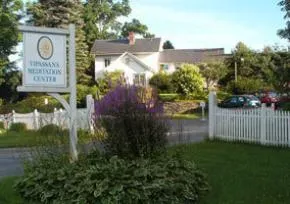 Dhamma Dharā — The center is situated on 108 acres of land in Shelburne, Massachusetts. The landscape has evolved from its original eight acres of meadowland, now encompassing a larger area that supports its extensive facilities. The environment is designed to foster a contemplative atmosphere, with ample space for quiet reflection.