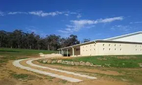Dhamma Padipa — The center is set on 32 hectares of gently undulating rural land, characteristic of the Shire of Brookton. It borders the Strange Road Nature Reserve and is enveloped by a dense corridor of native gum trees, acacias, and casuarinas. The property ascends to an eastern boundary, offering scenic views of a large granite outcrop and the valley below, ensuring a tranquil and secluded atmosphere.