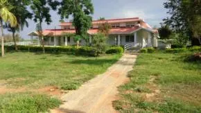 Dhamma Paphulla — The center is situated on a 10-acre plot, characterized by gently sloping land and rustic charm. It's bordered by farmland on one side and forestland on the other, creating a peaceful and secluded atmosphere that feels far removed from city life, despite its proximity to Bangalore.