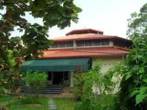 Dhamma Sobhā — The center is situated in Kosgama village, about 47 kilometers from Colombo, on a six-acre property. It is characterized by picturesque surroundings, completely encircled by a range of mountains. This natural amphitheater provides a tranquil backdrop for meditation, and on clear days, the sacred Adam’s Peak is visible in the distance.