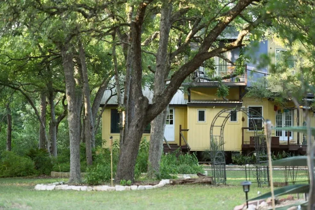 Austin Integration Coaching — The retreat is situated on seven acres in Manchaca, a short drive from downtown Austin. It's enveloped by a creek and a heavily wooded escarpment, providing a peaceful sanctuary. The property is surrounded by thousands of acres of undeveloped land, creating a raw yet comfortable atmosphere. Local lore suggests a meteorite impact created an unexplainable energy vortex on the property.