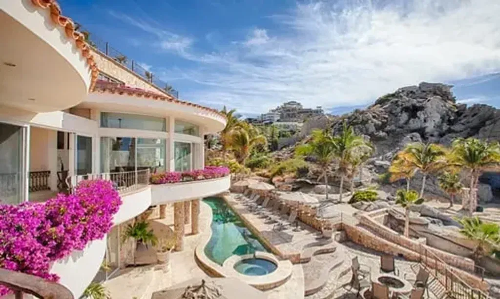 Baja Moon Yoga — The center is situated directly on the pristine Pedregal Beach in Cabo San Lucas, offering breathtaking views of the Pacific Ocean. The landscape is characterized by dramatic natural granite rock formations and lush coconut palms, creating a serene and private atmosphere right by the water's edge.