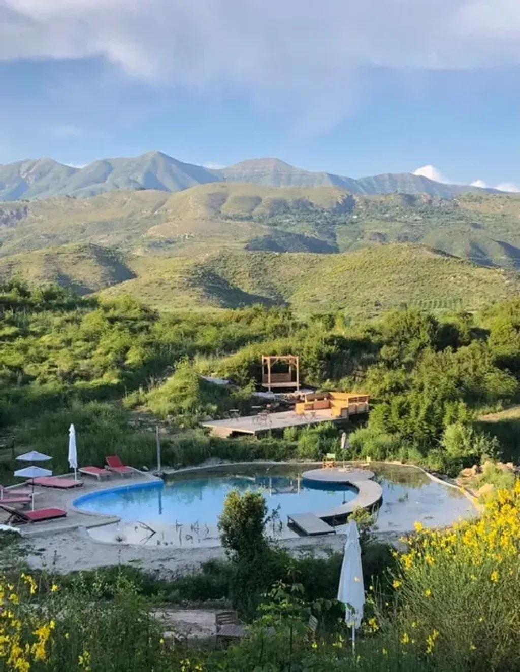 Bote Farms — Botë Farms is set within the breathtaking Albanian Riviera, surrounded by verdant countryside. The views are expansive and undisturbed, creating a profound sense of tranquility and escape. The landscape features olive groves, gardens, and a unique eco-pool, all contributing to an atmosphere of natural beauty and serene relaxation.