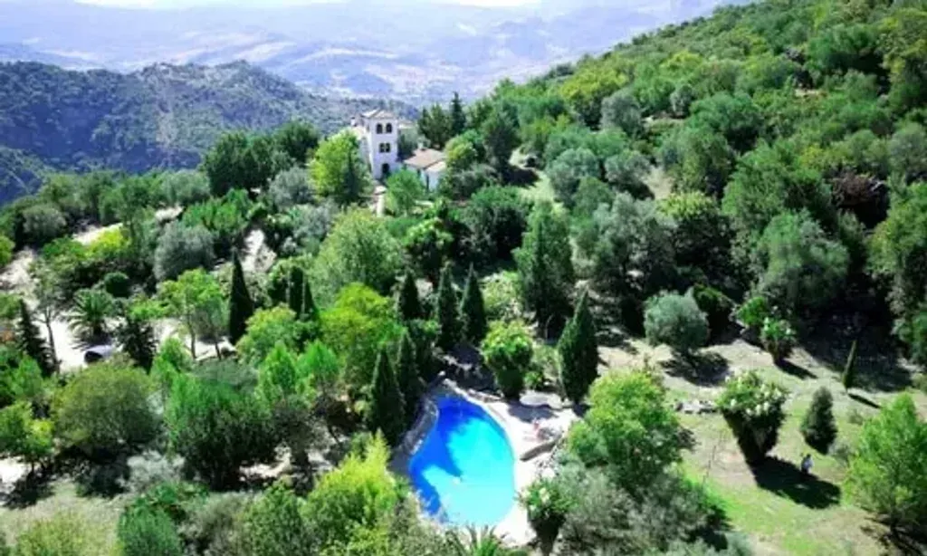 Elizabeth Phelan Pilates — set amidst the lush mountains of the Sierra de Grazalema National Park, the retreat center offers a truly immersive natural experience. The Andalucian sunlight bathes the landscape, illuminating panoramic views that stretch across the reserve. It's a place designed for sensory withdrawal, allowing guests to attune to the natural rhythms of the environment.
