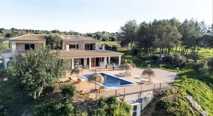 Elle Mace Coaching — set in Alcúdia, Mallorca, the retreat venue is a private villa offering beautiful views and lush gardens. Guests can enjoy the outdoor dining area, a refreshing swimming pool, and various lounges and seating areas dotted around the property, all contributing to a relaxed and serene atmosphere.