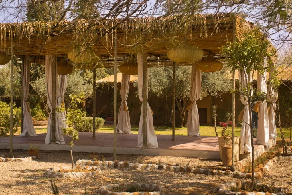 fawakay villas — Fawakay Villas is set amidst expansive gardens in the Moroccan countryside, offering a peaceful escape from the bustling city of Marrakech. The venue boasts a shaded yoga shala and a rooftop practice space with views that stretch across the landscape, sometimes even revealing the Atlas Mountains. The atmosphere is one of relaxed tranquility, with inviting pools and comfortable outdoor lounging areas.