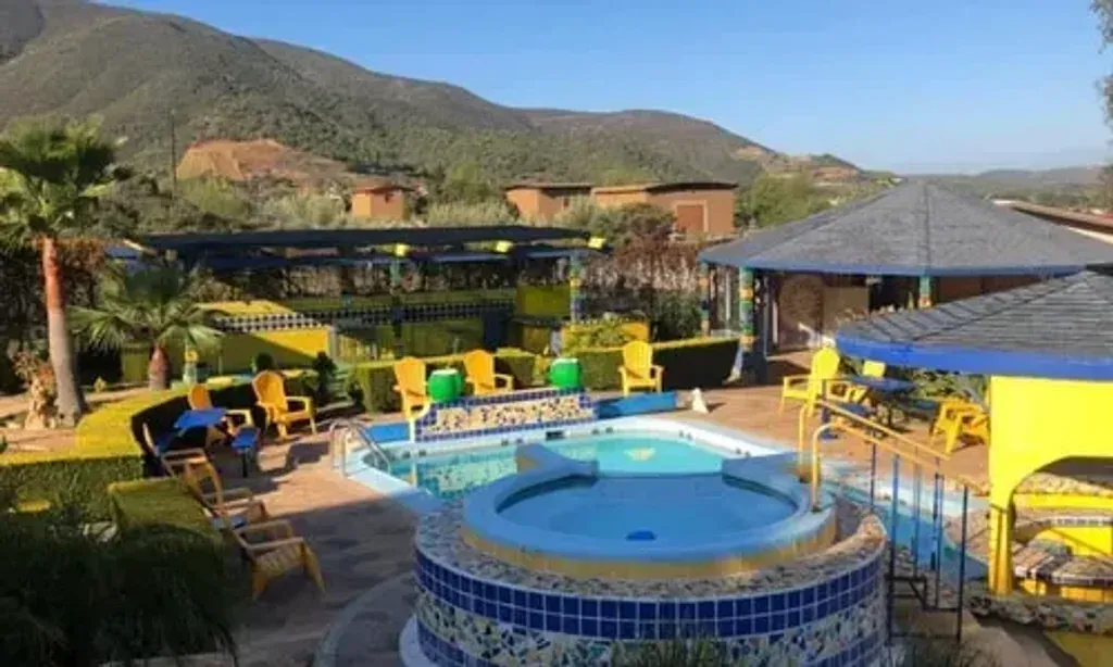 Gaia Camino — Gaia Camino is situated in the mountains of Baja California's wine country, near San Antonio de las Minas. The area is characterized by its desert-like terrain, yet the retreat itself is a verdant oasis thanks to sustainable water techniques. The climate is consistently mild, avoiding extremes of heat or cold, making it comfortable year-round. The atmosphere is one of warmth and personal connection, reflecting its history as a family home.