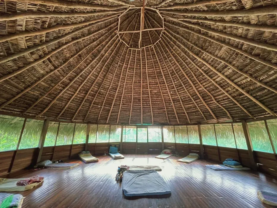 Jakon Rate — The center is situated on 65 acres of beautiful land outside Pucallpa, Peru. It offers a traditional, non-luxury environment, featuring a maloka for ceremonies, a communal kitchen and dining area, and walking trails amidst the natural surroundings. The atmosphere is one of familial warmth and deep connection to the land.
