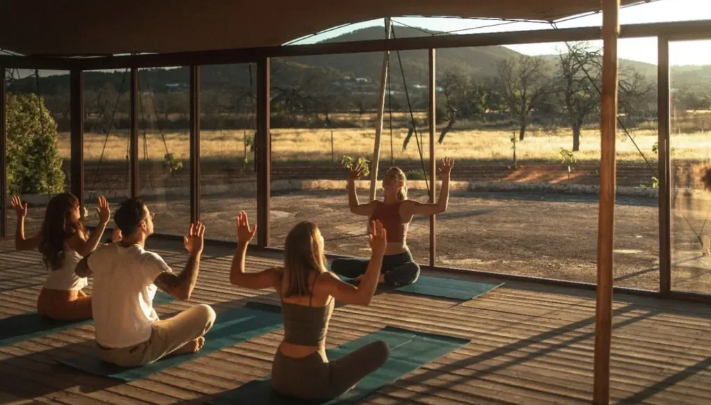 MANA YOGA — set in a picturesque almond valley in Santa Agnés, the retreat takes place at Es Cucons, a family-run Ibiza hotel. The venue is a beautifully reformed 1652 farmhouse, exuding a sense of history and charm. The atmosphere is one of a true home away from home, blending art and design with the natural beauty of the surroundings.