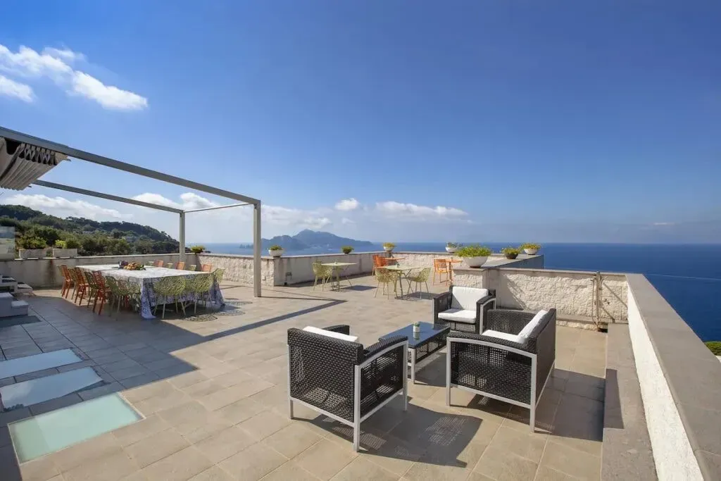 MCROUS LLC — The retreat unfolds in a beautiful villa set amidst ancient olive trees and vibrant Mediterranean vegetation. The property boasts a stunning pool area with direct views of the island of Capri, providing a picturesque backdrop for relaxation and activity. Numerous common areas and secluded spots ensure guests can find privacy for reading or simply admiring the breathtaking scenery.