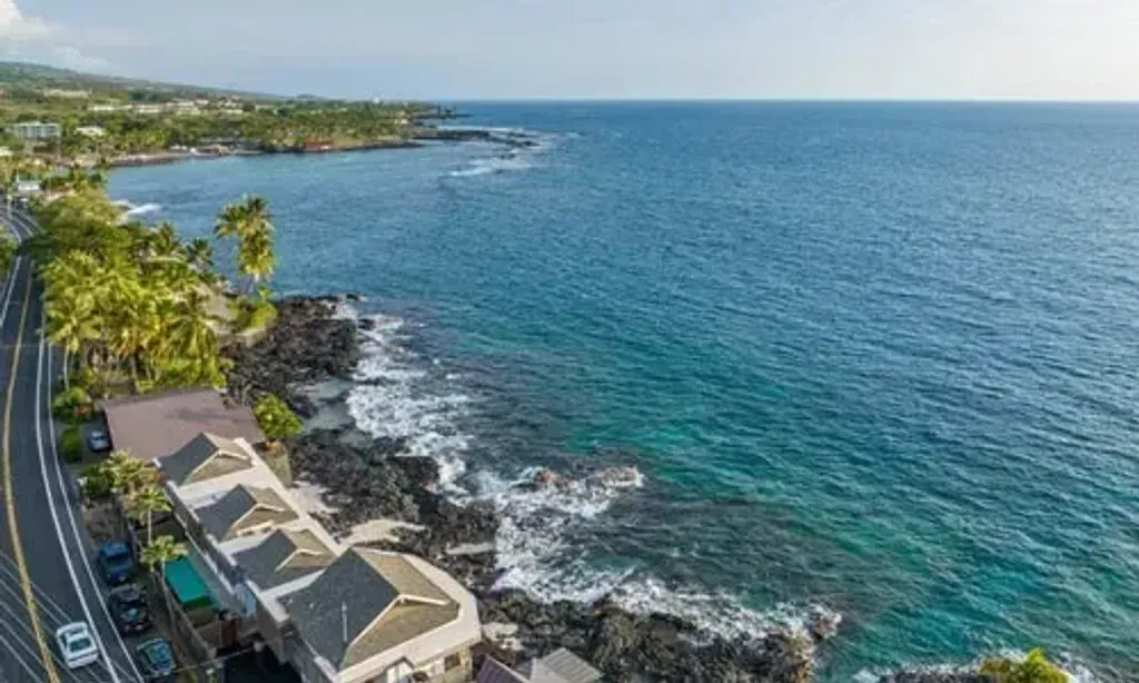 Mele Kai — Perched directly on the oceanfront in Kailua-Kona, Hawaii, Mele Kai offers an idyllic escape. The atmosphere is one of serene tropical beauty, with the Pacific Ocean providing a constant, calming presence. Lush Hawaiian landscapes surround the property, inviting a deep connection with nature and fostering a sense of peaceful rejuvenation.