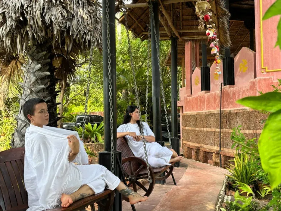Palm Garden Retreat — Palm Garden Retreat is a lush oasis where natural beauty meets conscious design. The property features thoughtfully landscaped grounds with meandering paths through bamboo groves and shaded palms, creating numerous quiet spots for reflection. A central lagoon-style pool blends seamlessly with the garden, offering a refreshing swim under the canopy. Common areas boast open corridors, carved wooden doors, and decorative lanterns, while a stunning dining area overlooks the pool and gardens, adorned with vibrant tiles and traditional motifs.