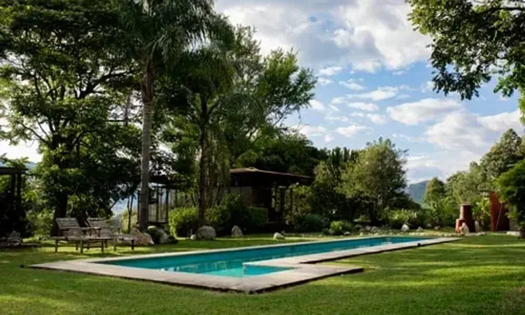 Sacred Seed — The estate spans 13 hectares, featuring sugar cane fields, fruit trees, flowering gardens, and native forests. A saltwater pool, spa, and meditation hall are available, surrounded by a mild climate conducive to tranquility. Vibrant gardens for medicinal plants and a wildlife sanctuary, along with a river path and ceremonial spaces, create a serene and protected environment.