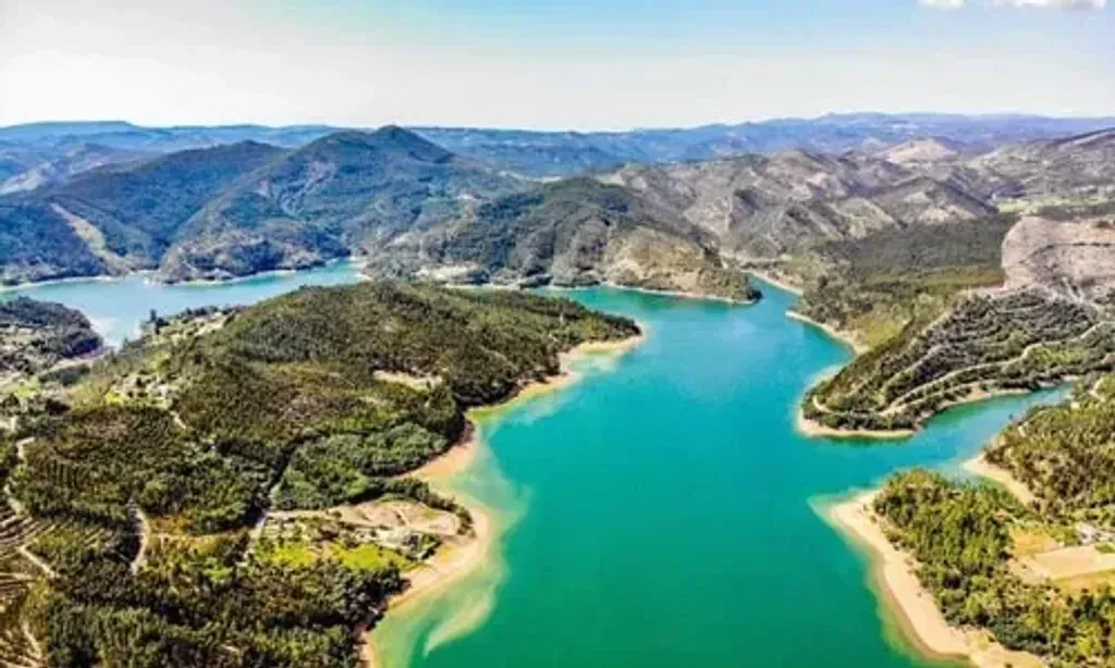 The Freedom Tribe — The retreat unfolds in a magical 'living temple' set near the Rio Zêzere, about 100 km northeast of Lisbon. Surrounded by Mediterranean nature, ancient mountains, and a vibrant night sky, the venue offers a profound connection to the earth and plant spirits, creating an atmosphere of deep natural immersion.