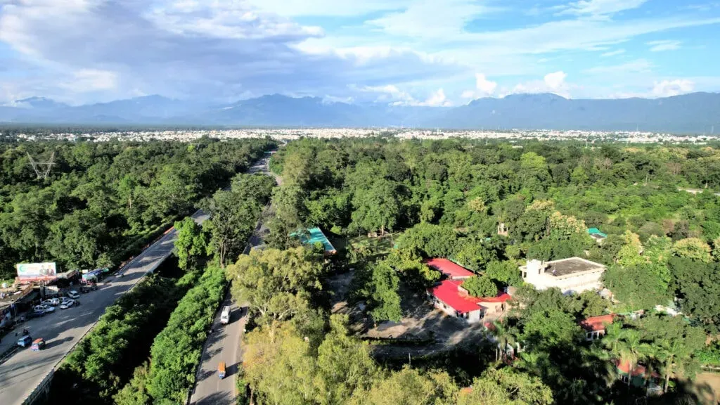 The Palms Resort — Located in Rishikesh, a city renowned for its spiritual significance and its position on the Ganges River, The Palms Resort offers a peaceful environment. The surrounding area is characterized by the foothills of the Himalayas, lush greenery, and the calming presence of the holy river, providing a natural backdrop for relaxation.