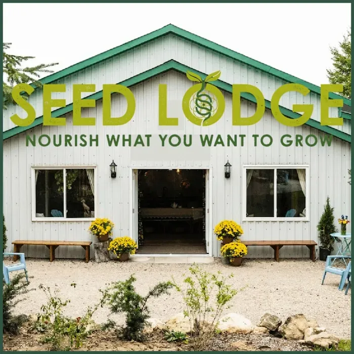 The SEED Lodge — The SEED Lodge is situated in the serene landscape of Meaford, Ontario, offering a tranquil escape from the everyday. The property features a white lodge with a green roof and a sauna out front, creating a welcoming and peaceful atmosphere. Surrounded by nature, it provides an ideal backdrop for introspection and creative exploration.