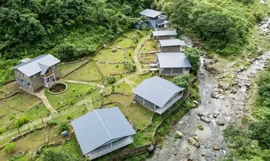 Vanadevi Retreat — Vanadevi Retreat is set in the quiet hills just outside Dehradun, Uttarakhand. Though close to the city, its location slightly off the main road ensures natural silence and seclusion. The final approach involves a gentle fifteen-minute walk through a forest landscape, creating a soft transition into the tranquil environment.