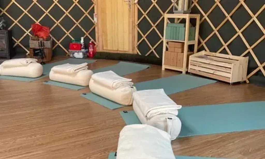 Yogilu Yoga & Wellness — The center is situated in a picturesque yoga yurt, set within the peaceful English countryside. The atmosphere is one of calm and natural beauty, providing a serene backdrop for yoga practice and relaxation.